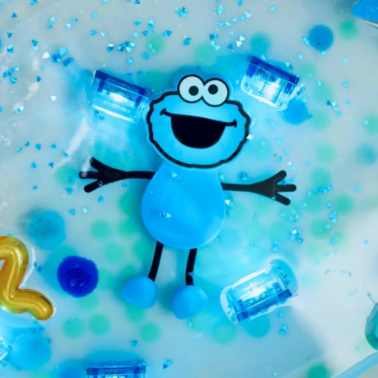 Dziecko wyławiające niebieskie kostki Glo Pals z piany w wannie
