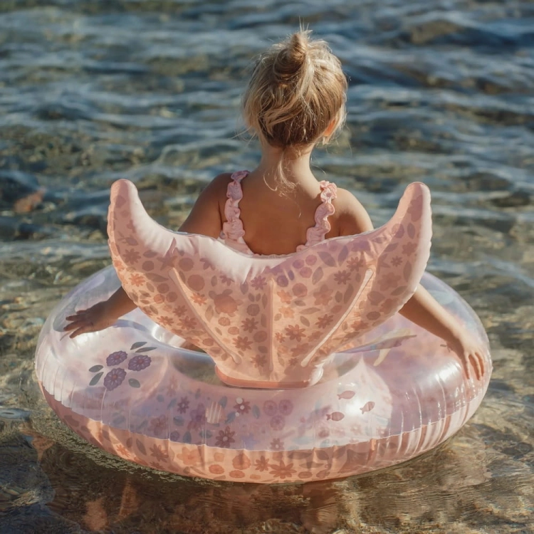 Dziewczynka siedząca w kole do pływania Dreamy Mermaid Little Dutch 91cm w morzu – widok od tyłu, różowe koło z ogonem syreny