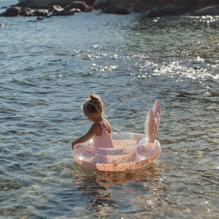 Dziecko w różowym kole do pływania Dreamy Mermaid Little Dutch 91cm w morzu – nadmuchiwane koło z ogonem syreny, zabawka plażowa