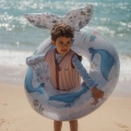 Chłopiec z kołem do pływania Ocean World 91cm Little Dutch na plaży – niebieskie koło z ogonem wieloryba i nadrukiem zwierząt morskich