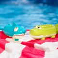 Zestaw dwóch sikawek rekin i krokodyl BX1551Z B.Toys – niebieska sikawka rekin i zielona sikawka krokodyl przy basenie na ręczniku plażowym