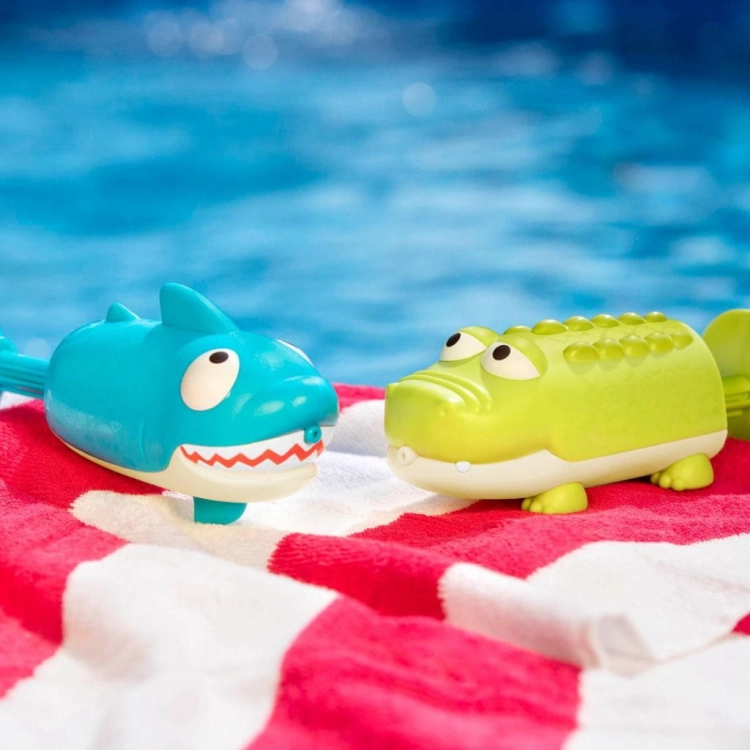 Zestaw dwóch sikawek rekin i krokodyl BX1551Z B.Toys – niebieska sikawka rekin i zielona sikawka krokodyl przy basenie na ręczniku plażowym