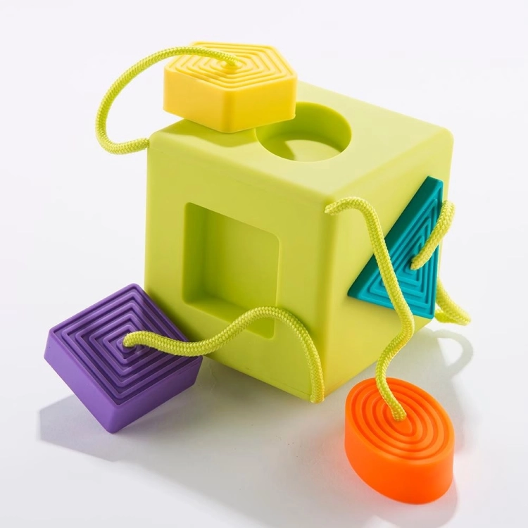 Sorter Kostka OombeeCube Fat Brain Toys – zielona sensoryczna kostka z kolorowymi kształtami na sznurkach, zabawka edukacyjna dla niemowląt od 6 miesiąca