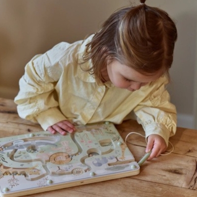 Dziewczynka w żółtej koszuli przesuwa rysikiem kulki w labiryncie magnetycznym Little Dutch Safari Friends