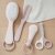 Nożyczki Beaba Old Pink obok szczotki, grzebienia i pilnika z zestawu do pielęgnacji niemowlaka