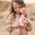 Dziewczynka przytula flaminga Little Dutch Safari Friends 35 cm, widoczny sztruksowy brzuszek