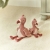 Dwie przytulanki flaminga Little Dutch Safari Friends w rozmiarze 35 i 25 cm siedzące na dywanie