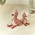 Dwie przytulanki flaminga Little Dutch Safari Friends w rozmiarze 35 i 17 cm siedzące na dywanie