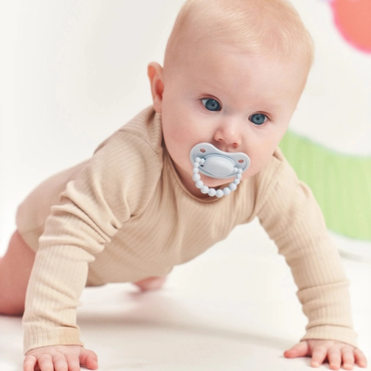 Smoczek pozycjonujący LUU Kids Baby Dove - przód tarczy z uchwytem z silikonowych kuleczek z dzieckiem