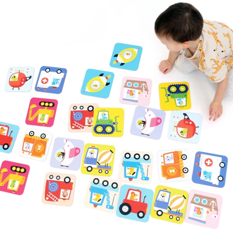 Dziecko przygląda się kartom memory CzuCzu z pojazdami rozłożonym na podłodze