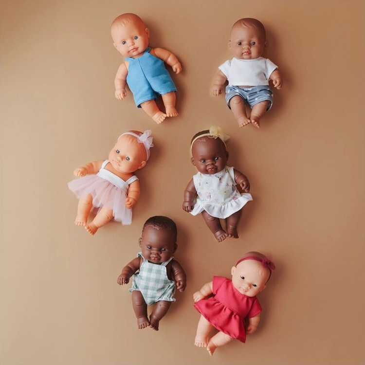 Kolekcja lalek Miniland Baby 21 cm o różnych karnacjach, w tym dziewczynka w białej sukience w kwiaty, widok z góry