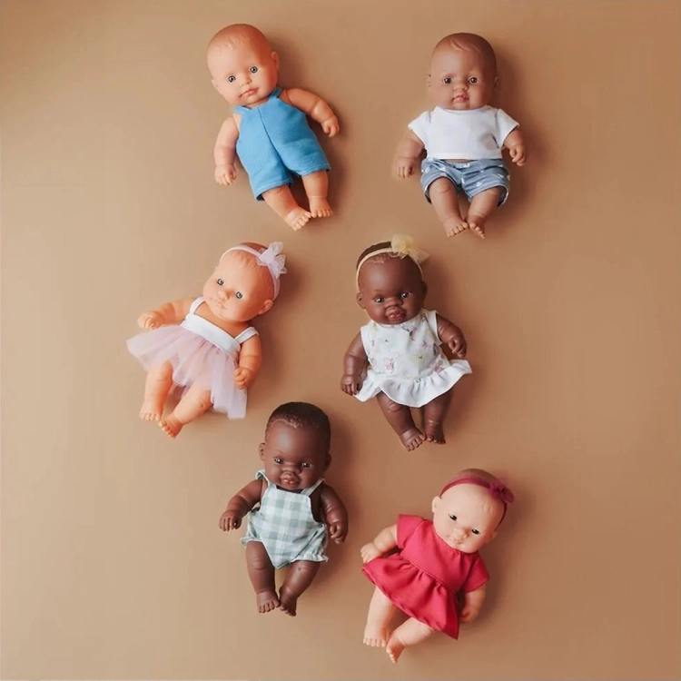 Sześć lalek Miniland Baby 21 cm w różnych strojach, w tym dziewczynka w malinowej sukience i bordowej opasce