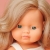 Zbliżenie na twarz lalki Miniland 38 cm: zielone oczy i długie, falowane ciemne blond włosy